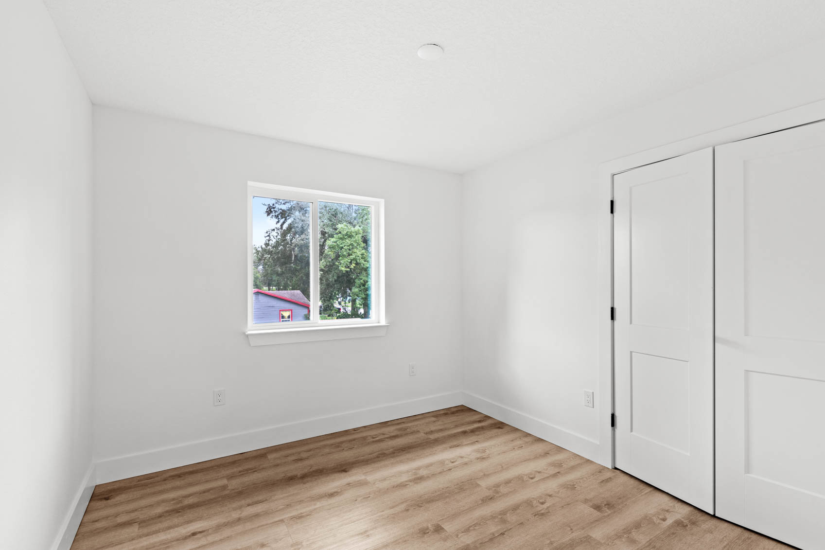 bedroom with white walls and wooden floors